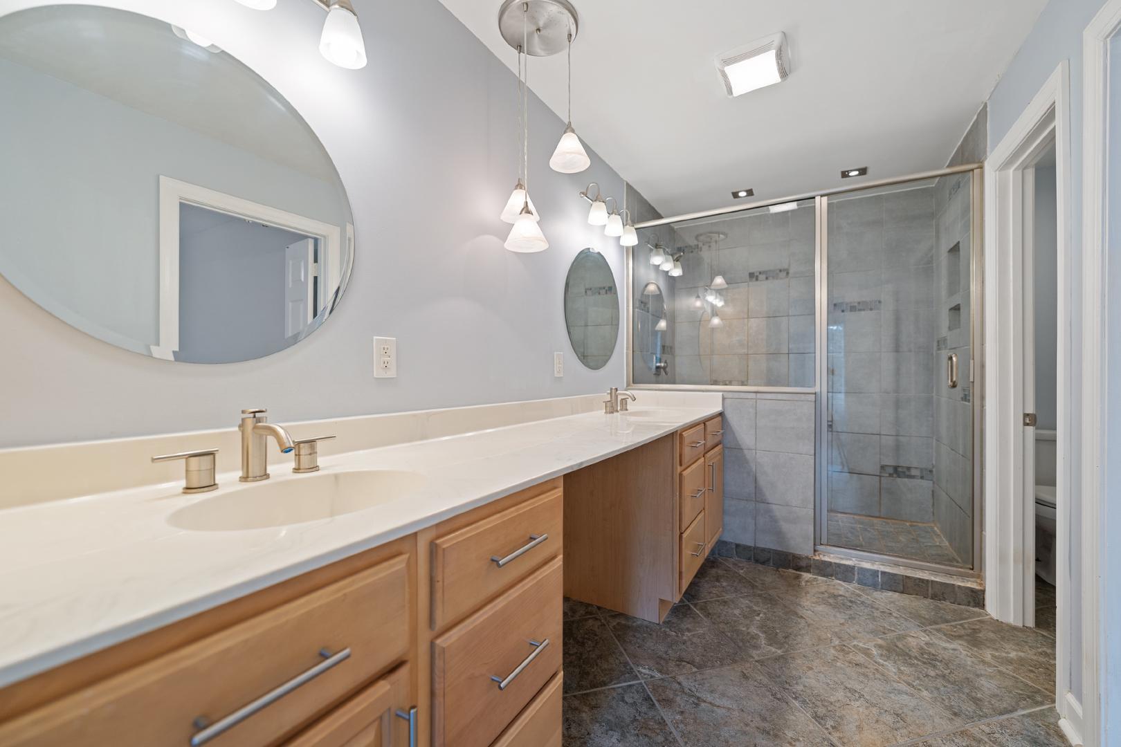 4111 Settlement Drive Durham, NC 27713 - Photo 9 of 16 a bathroom with a double vanity sink mirror and shower