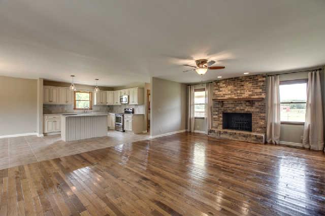 Gorgeous open space with wood burning fireplace and hardwood flooring.
