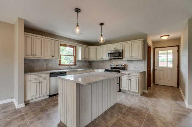Lovely kitchen with new cabinetry, lighting, granite, tile splash and Stainless Steel Appliances.