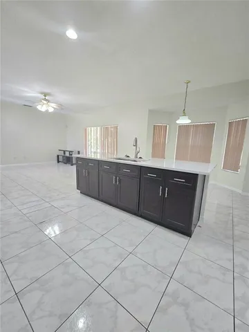 a large room with granite countertop a cabinets and wooden floor