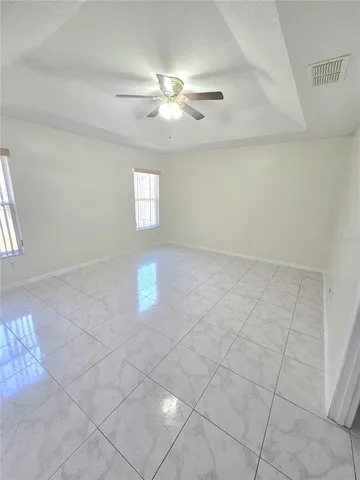 an empty room with windows and fan