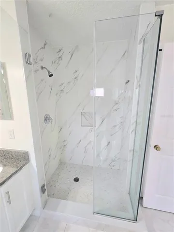 a bathroom with a granite countertop shower
