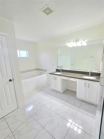 a view of a kitchen with white cabinets