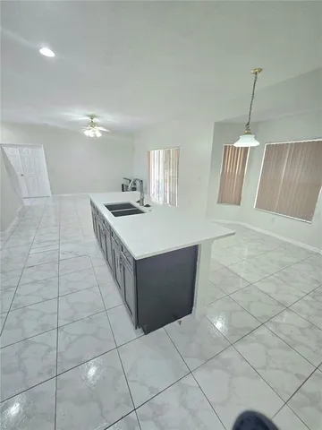 a kitchen with stainless steel appliances a sink a stove a counter top space and cabinets