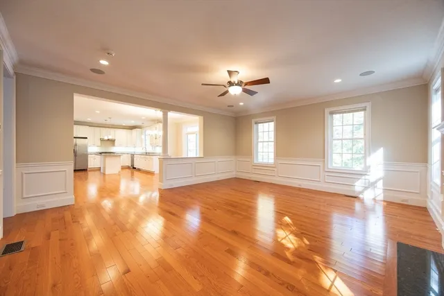 a view of an empty room with window and wooden floor