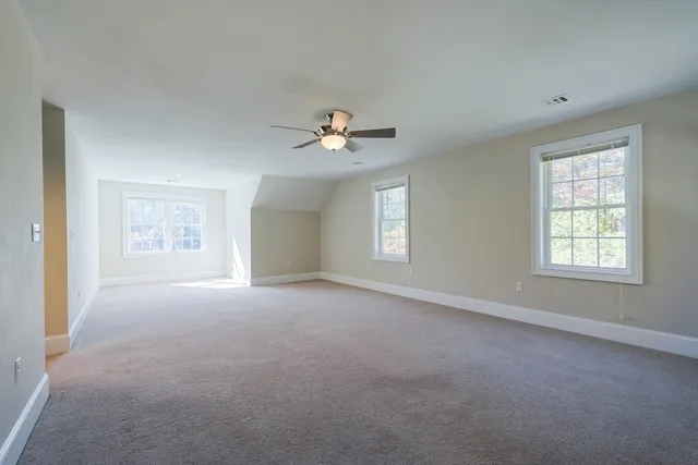 an empty room with a ceiling fan and window