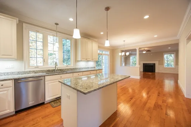 a kitchen with stainless steel appliances granite countertop a sink a stove and a wooden floor