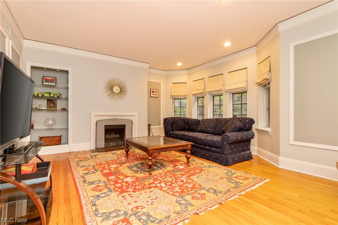 2515 Overlook Road, Unit 14 Cleveland, OH 44106 - Photo 2 of 20 Living room featuring ornamental molding, light wood-type flooring, and built in shelves