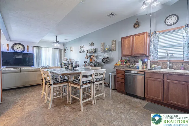 a kitchen with a dining table chairs sink and cabinets