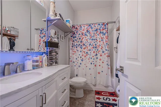 a bathroom with a sink a toilet and shower curtain