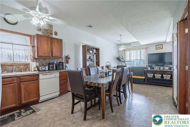 a open dining room with stainless steel appliances kitchen island granite countertop furniture and a kitchen view