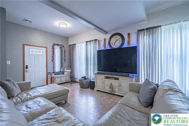 a living room with furniture a large window and a flat screen tv
