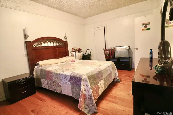 a bedroom with a bed flat screen tv and dresser