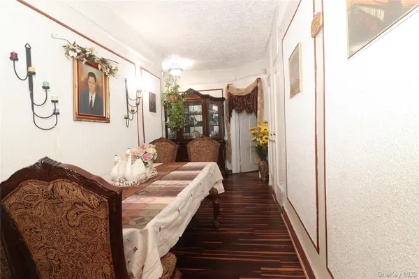 a dining room with chandelier and wooden floor