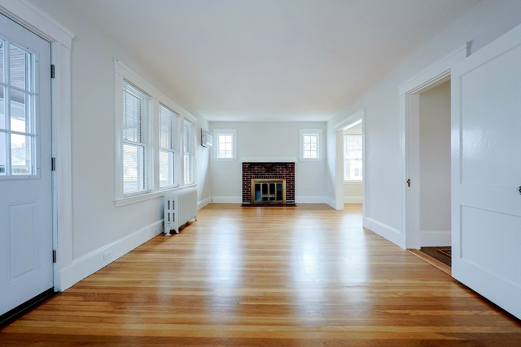 33 Woodleigh Road, Unit 2 Watertown, MA 02472 - Photo 4 of 23 a view of a livingroom with wooden floor and a fireplace
