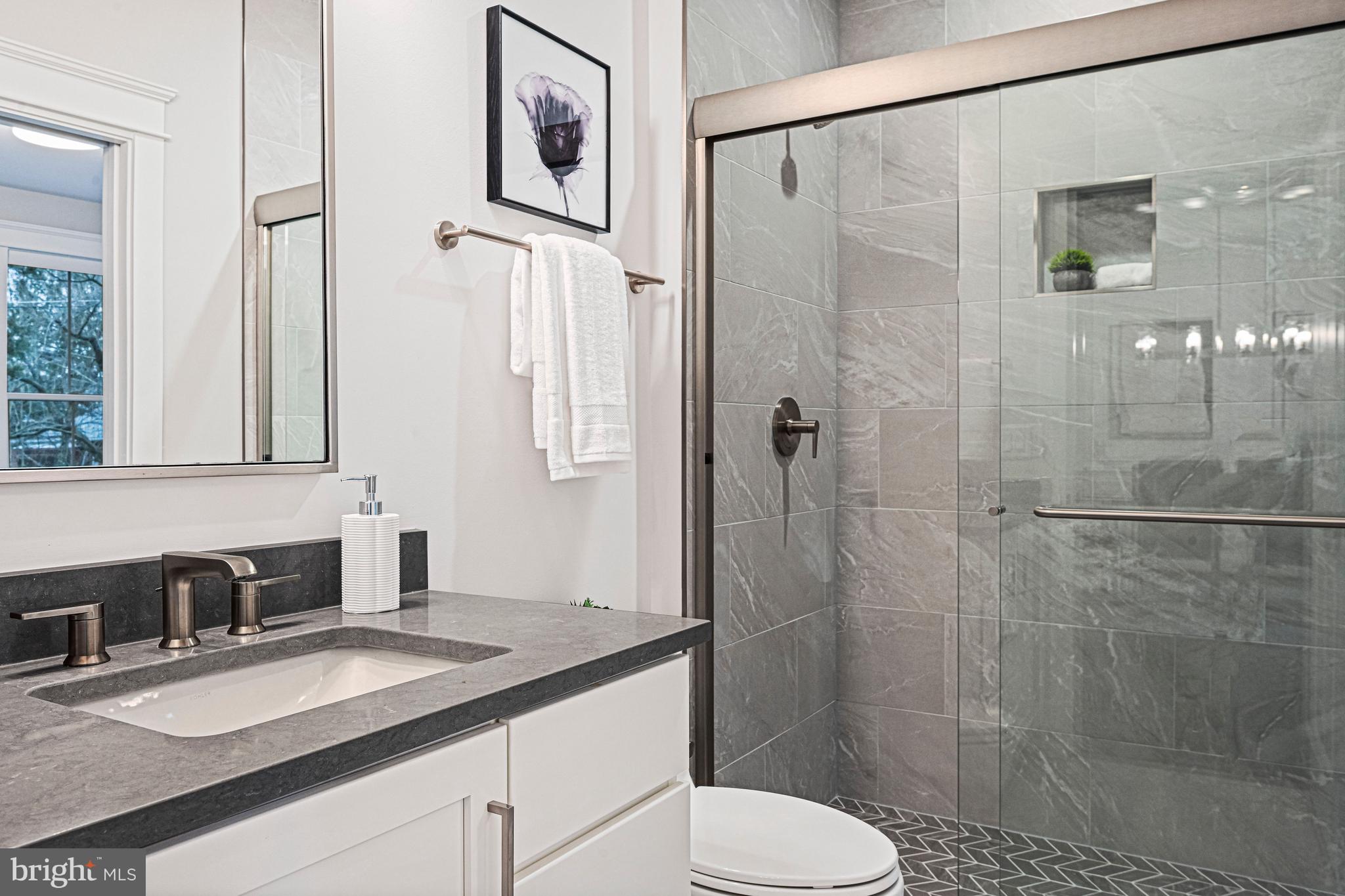 6447 Tucker Avenue McLean, VA 22101 - Photo 14 of 47 a bathroom with a granite countertop sink toilet and shower
