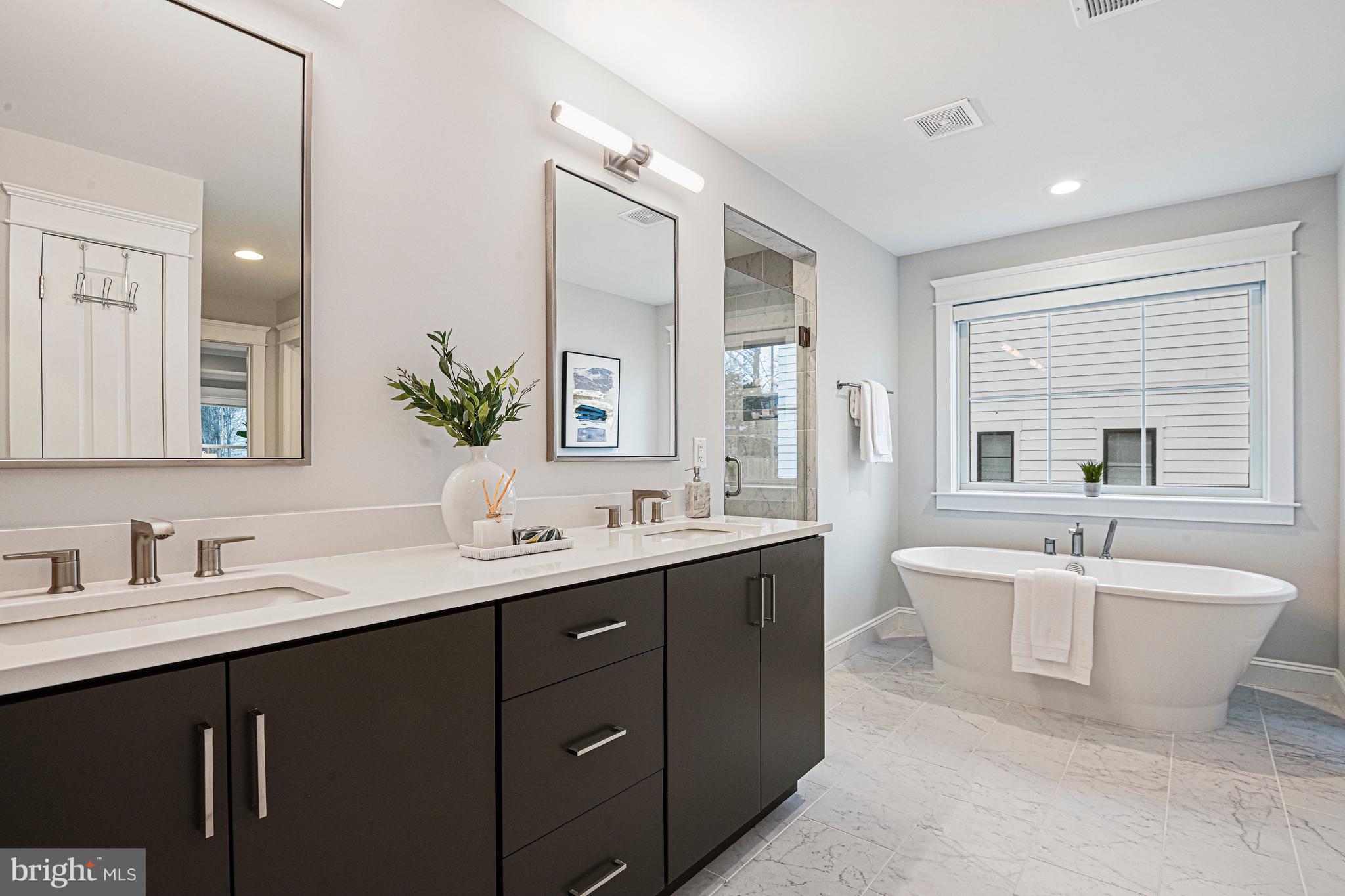 6447 Tucker Avenue McLean, VA 22101 - Photo 19 of 47 a spacious bathroom with a double vanity sink a large mirror and a bathtub