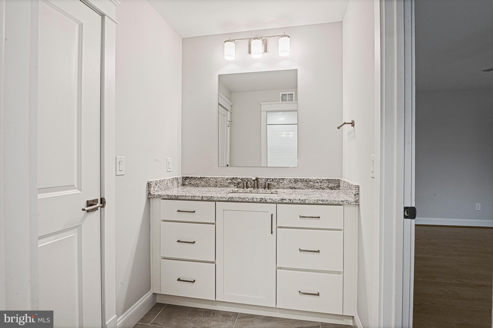 6447 Tucker Avenue McLean, VA 22101 - Photo 23 of 47 a bathroom with a granite countertop sink and a mirror