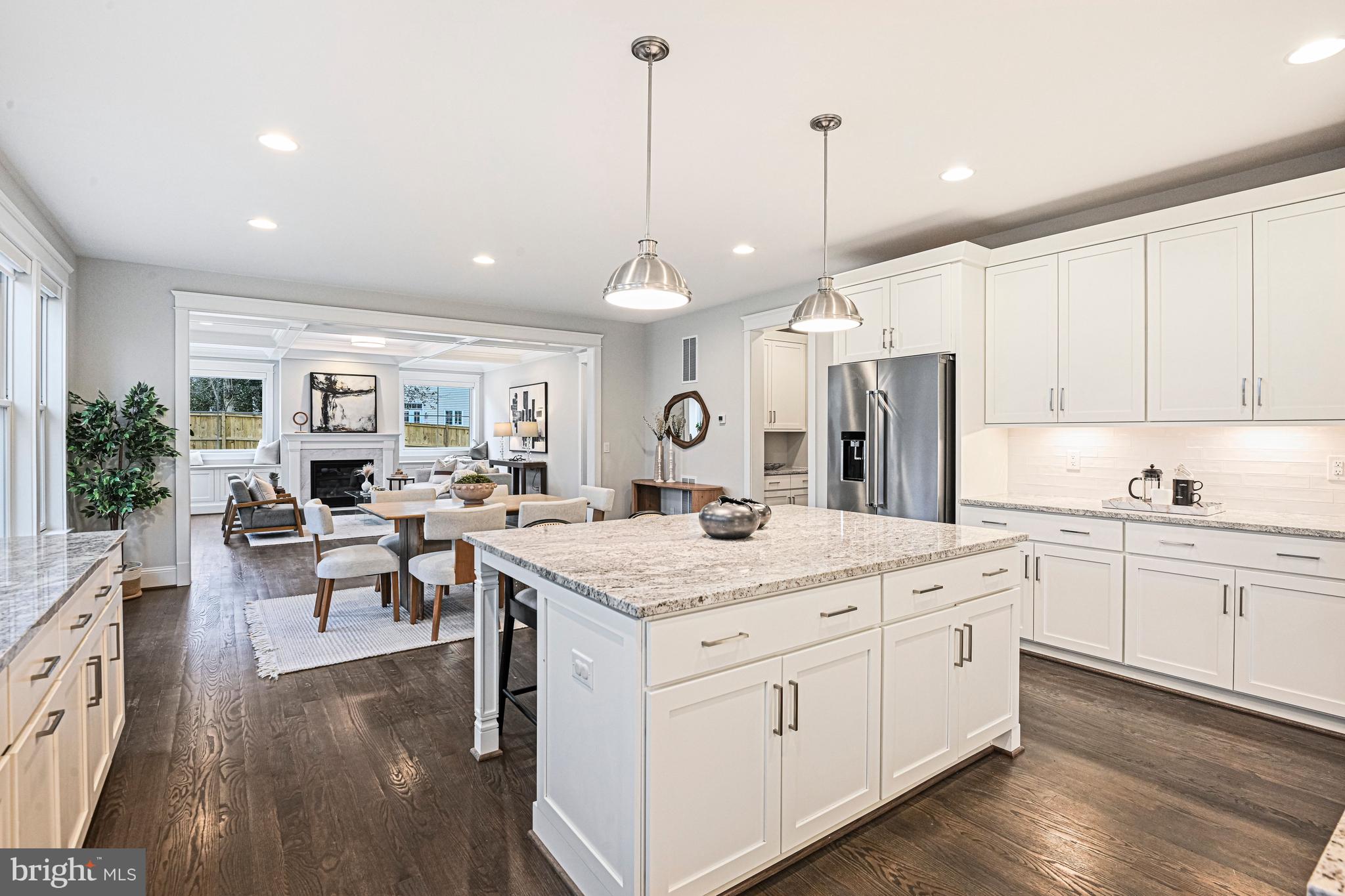6447 Tucker Avenue McLean, VA 22101 - Photo 8 of 47 a open kitchen with kitchen island a sink stove and white cabinets with wooden floor