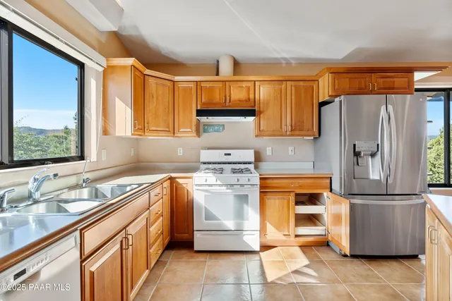 a kitchen with stainless steel appliances granite countertop a refrigerator sink and stove