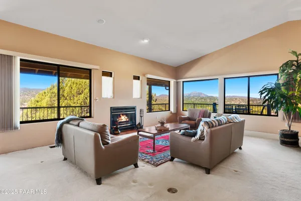 a living room with furniture fireplace and a large window