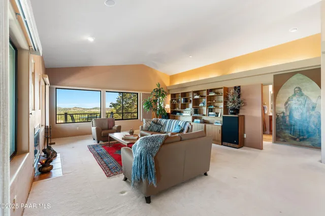 a living room with fireplace furniture and a large window
