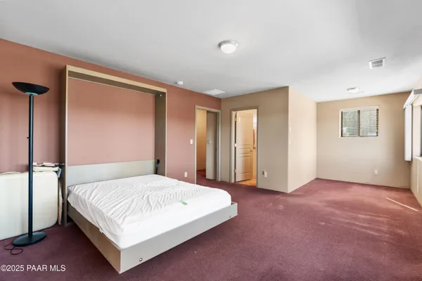 a bedroom with a large bed and a chandelier