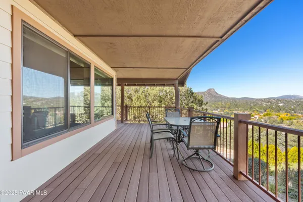 a view of a balcony with chairs and wooden floor