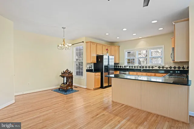 a living room with stainless steel appliances granite countertop a stove and a fireplace