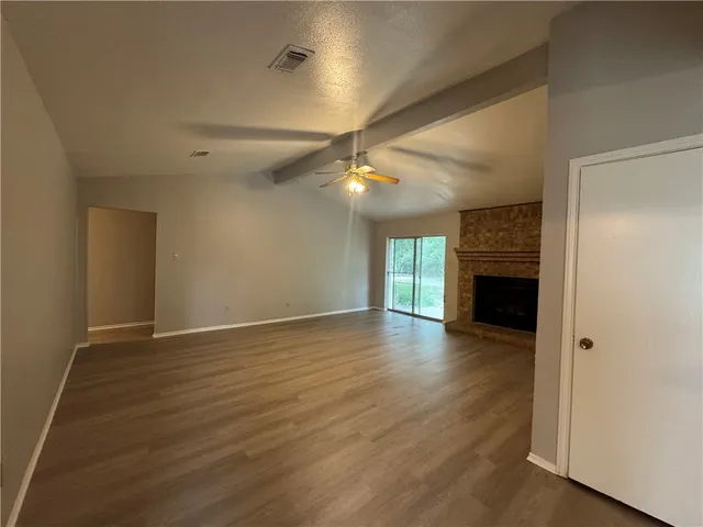 wooden floor in an empty room with a fireplace