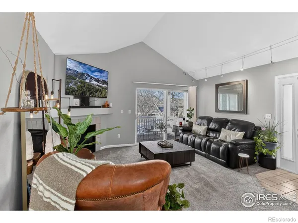 a living room with furniture a flat screen tv and a floor to ceiling window