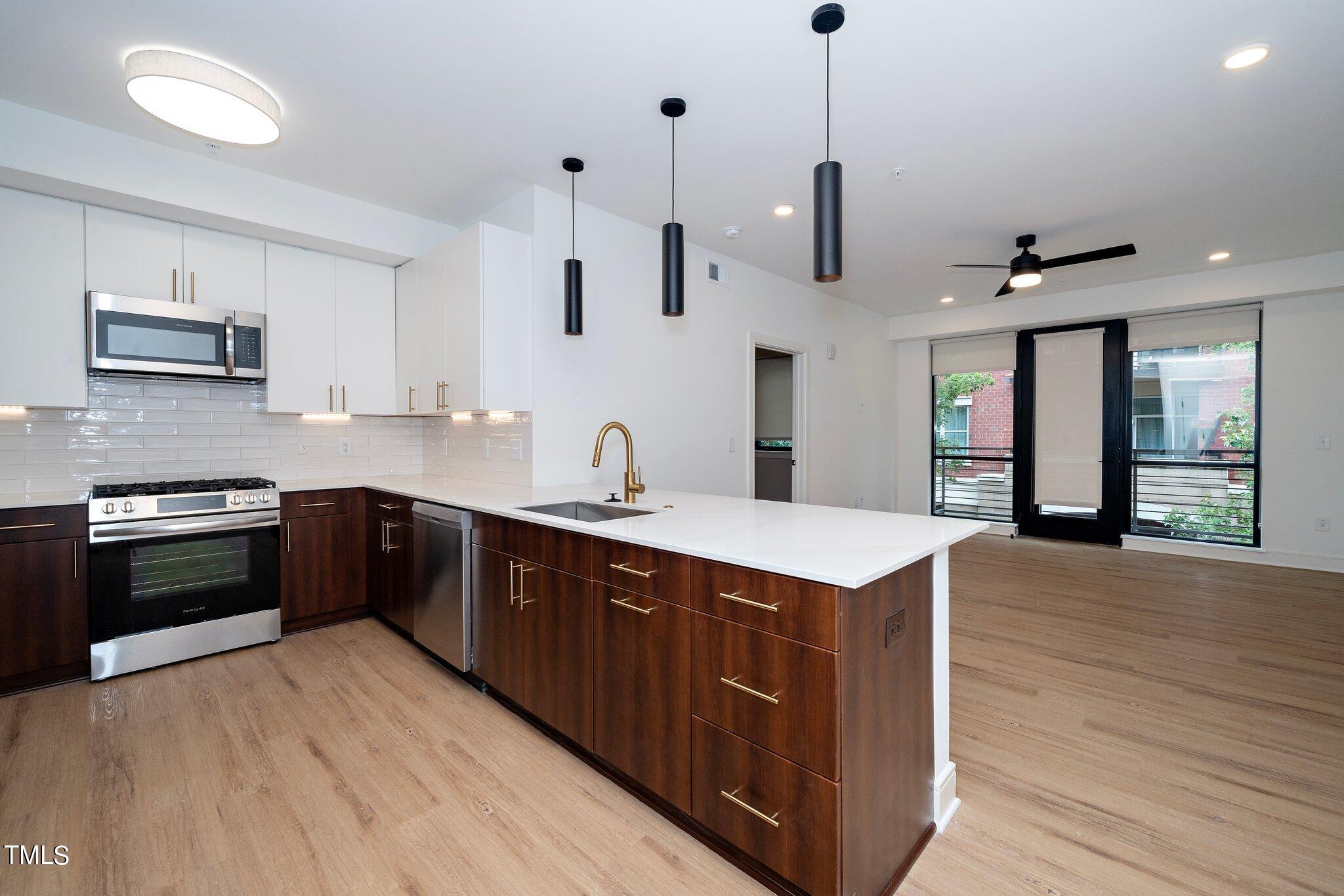 615 West Peace Street, Unit 306 Raleigh, NC 27603 - Photo 4 of 37 a kitchen with stainless steel appliances kitchen island a large island in the center and wooden floor