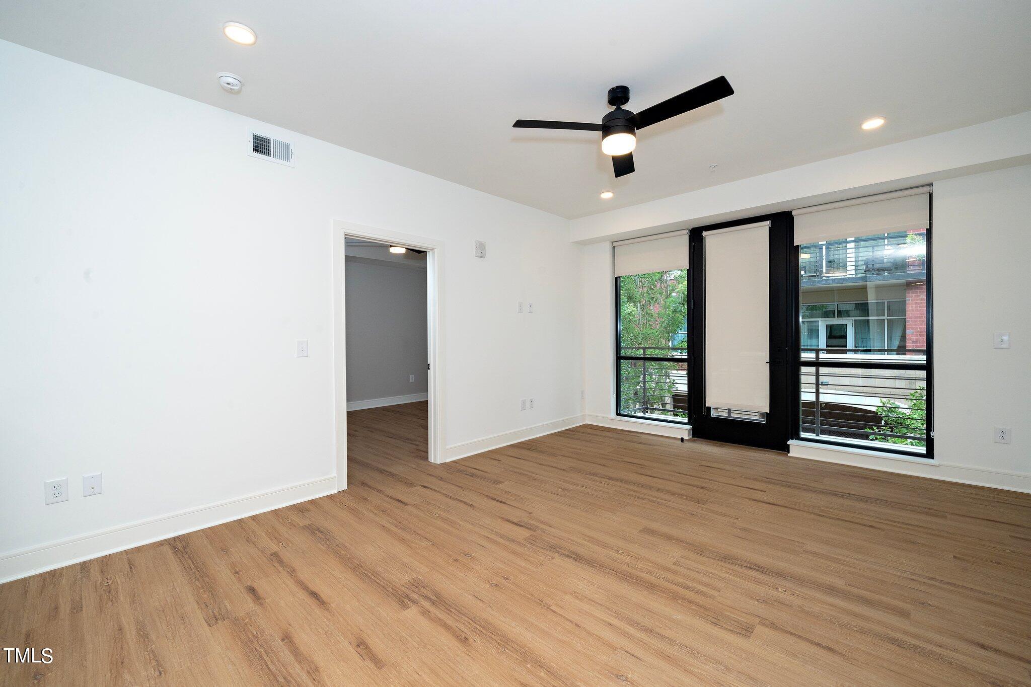 615 West Peace Street, Unit 306 Raleigh, NC 27603 - Photo 8 of 37 a view of an empty room with wooden floor and a window