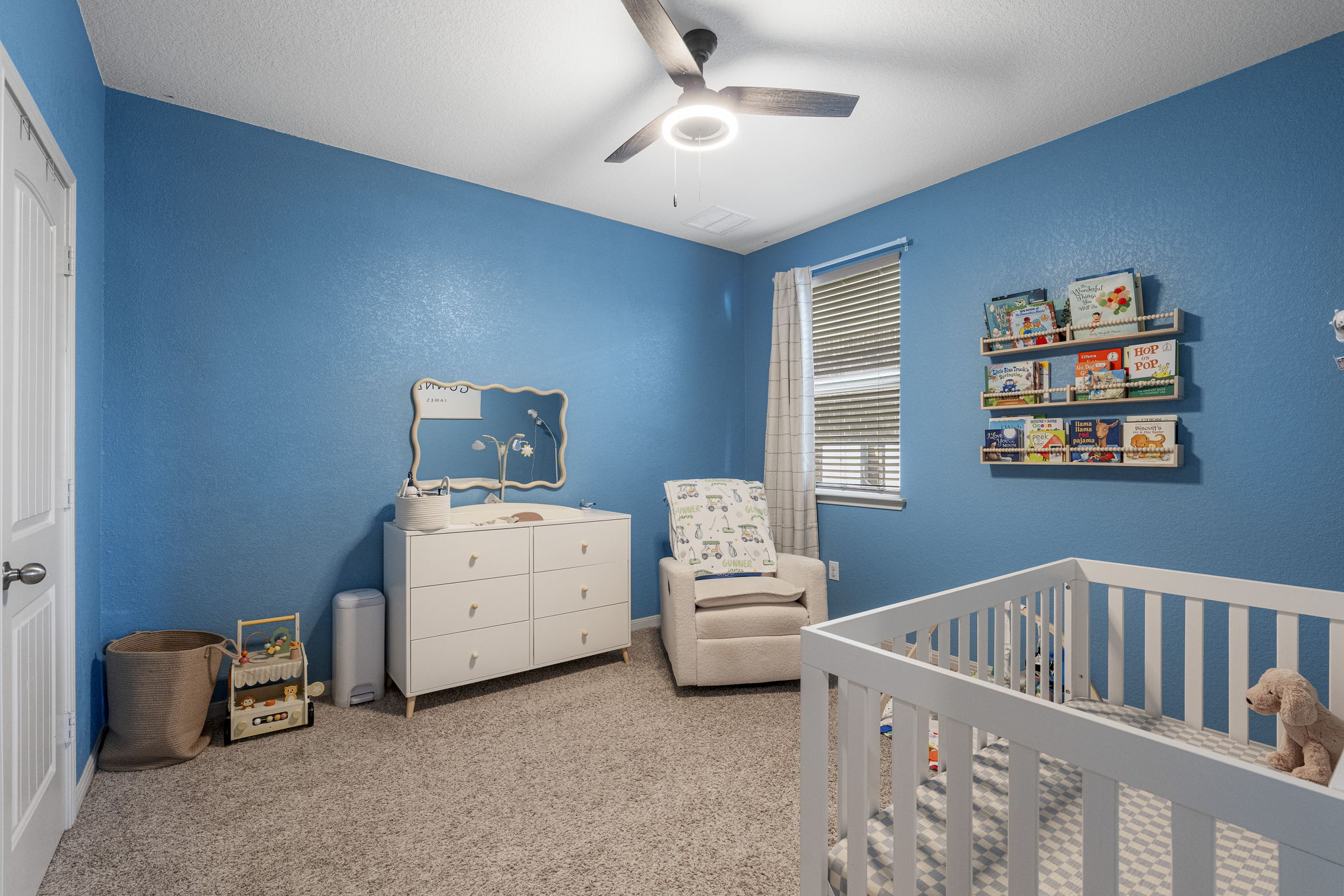 185 Struss Drive Georgetown, TX 78626 - Photo 17 of 23 Nurturing nursery features a neutral rug, inviting rocker, and built-in bookshelves for treasured stories.