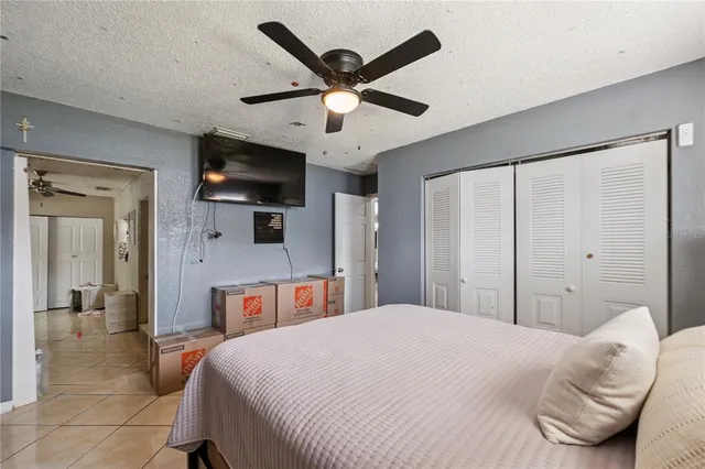 a bedroom with a large bed a flat screen tv and a walk in closet