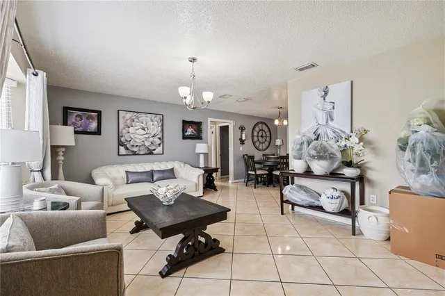 a living room with furniture a chandelier and a window