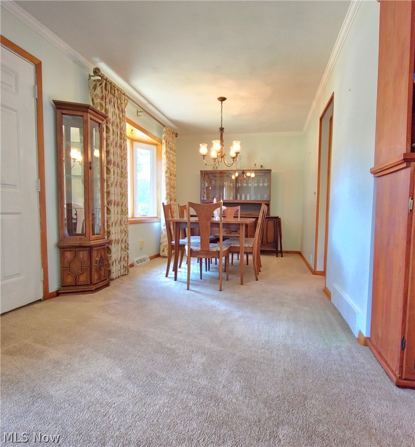 39195 Johnnycake Ridge Road Willoughby, OH 44094 - Photo 7 of 22 Carpeted dining space with a notable chandelier and crown molding