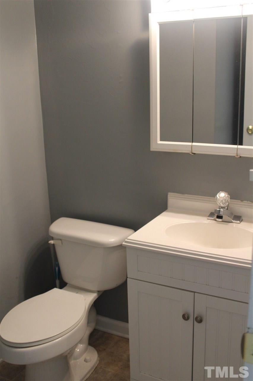 5911 Farm Gate Road Raleigh, NC 27606 - Photo 4 of 21 a white toilet sitting next to a bathroom sink