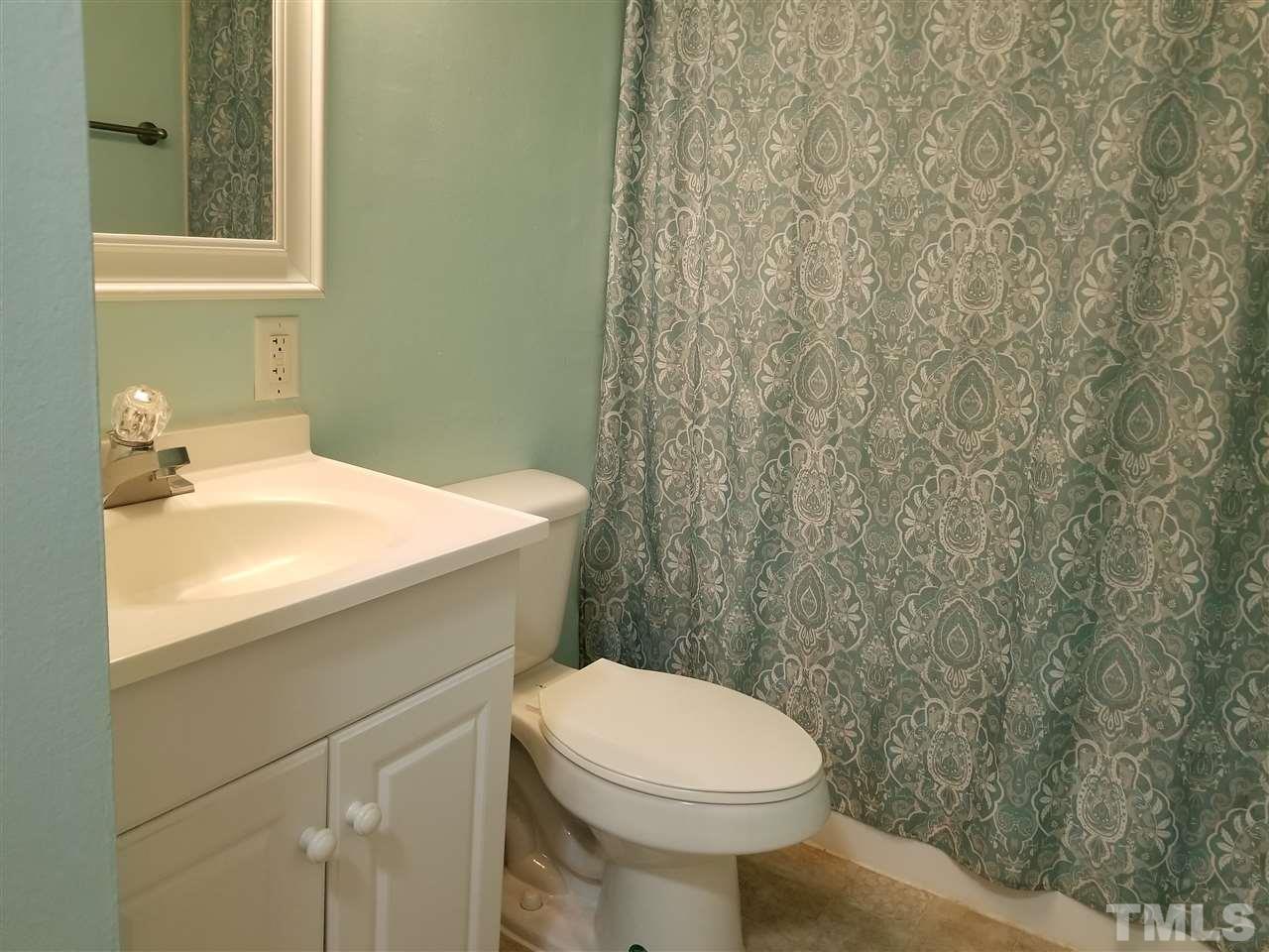 5911 Farm Gate Road Raleigh, NC 27606 - Photo 10 of 21 a bathroom with a sink a toilet and a mirror