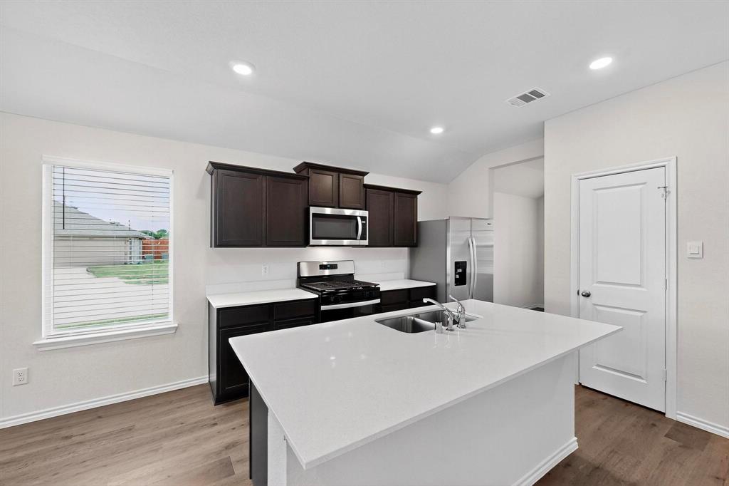 406 Regiment Road Sherman, TX 75090 - Photo 9 of 40 a kitchen with a stove a sink and a refrigerator