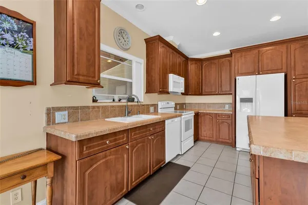 a kitchen with stainless steel appliances granite countertop a refrigerator a stove and a sink with granite countertops
