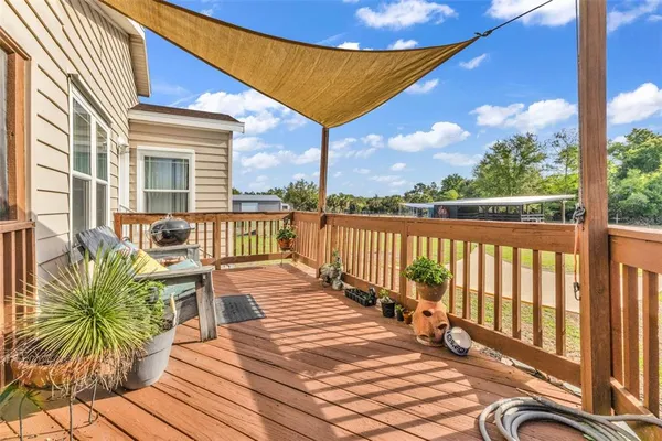 a balcony with wooden floor stairs and furniture
