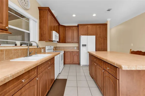 a kitchen with stainless steel appliances granite countertop a sink counter space cabinets and a large window