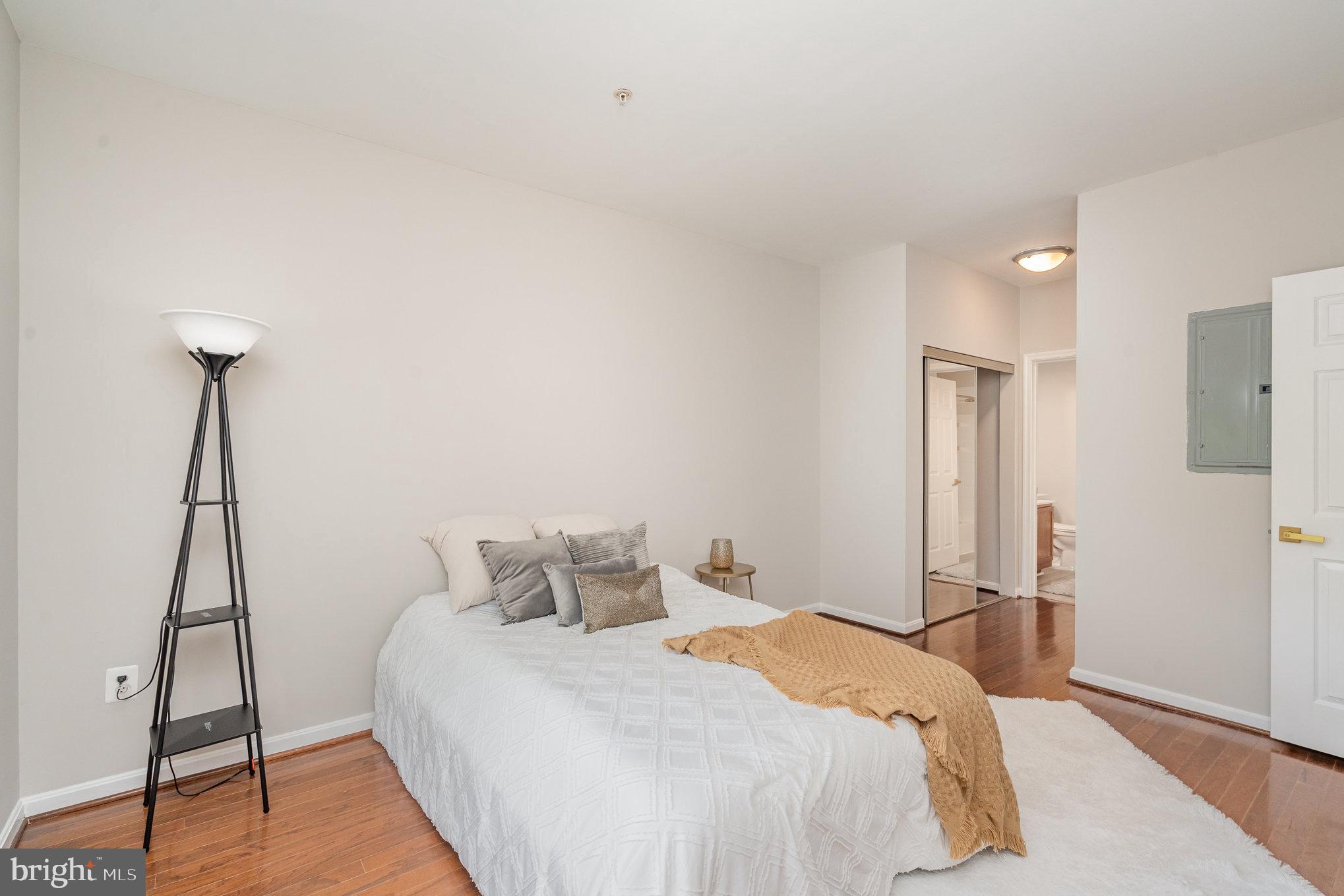 4850 Eisenhower Avenue, Unit 203 Alexandria, VA 22304 - Photo 11 of 24 a bedroom with a bed and a table