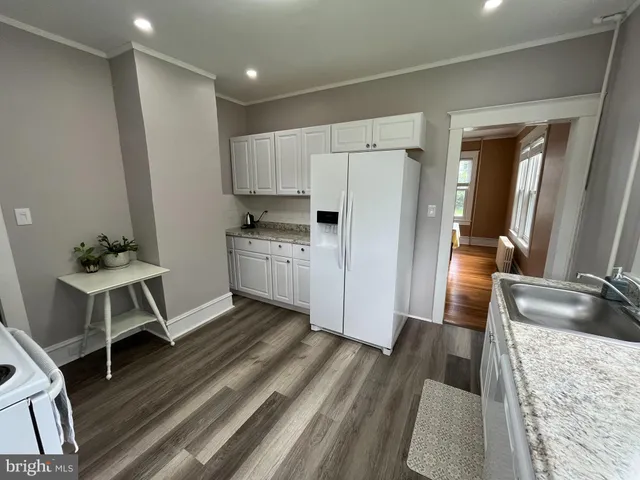 a kitchen with a sink appliances and wooden floor