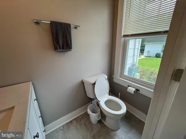 a white toilet sitting next to a bathroom sink and a window