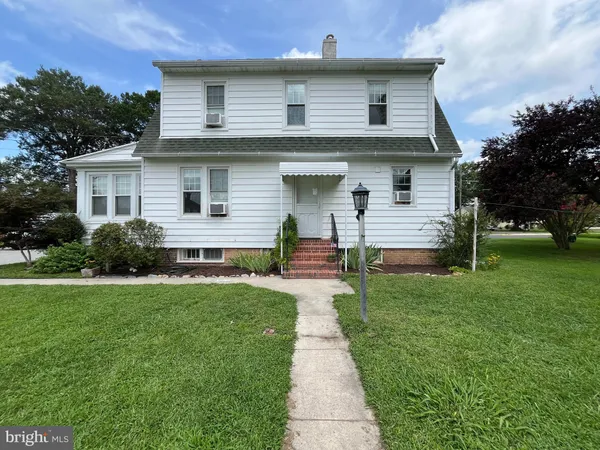 a front view of a house with a yard and trees