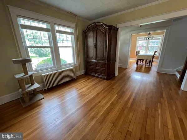 a view of empty room with wooden floor and furniture