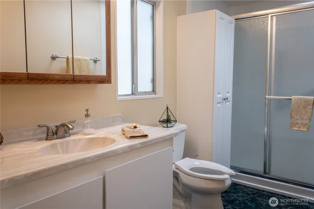 a bathroom with a sink a toilet and a mirror