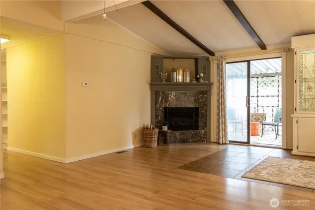 a view of a livingroom with wooden floor and a fireplace